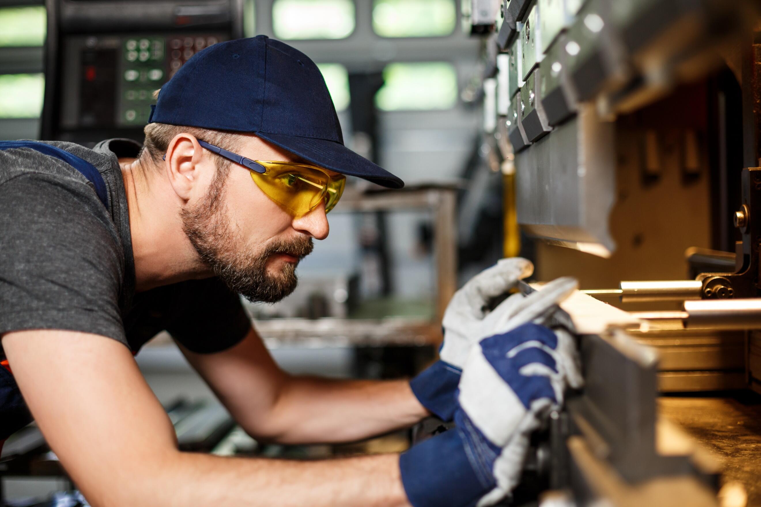 A person wearing goggles and gloves working on a machine

AI-generated content may be incorrect.
